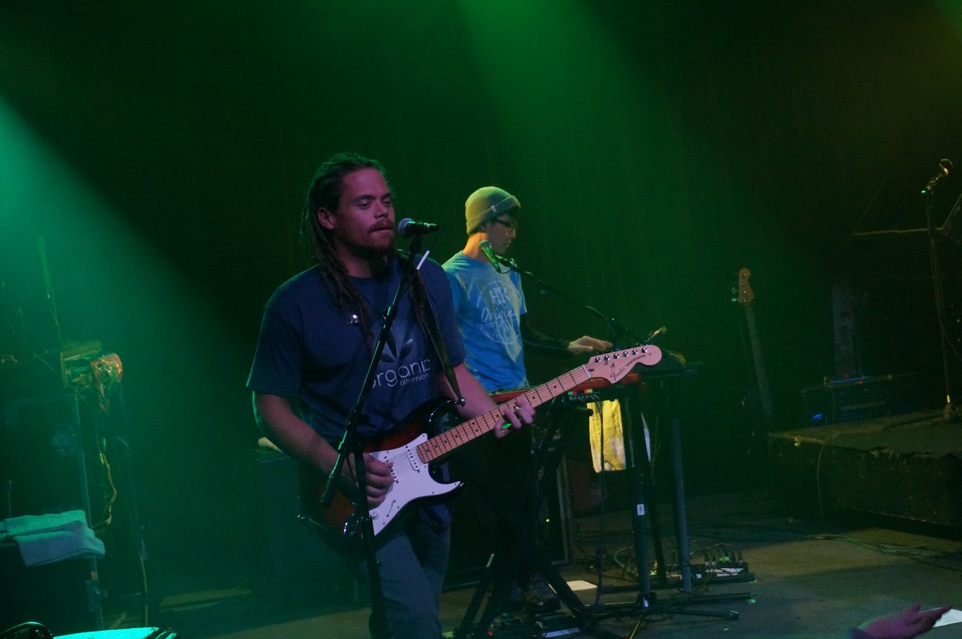 The Green performing live on stage, with a vocalist on guitar and a bandmate on keyboards